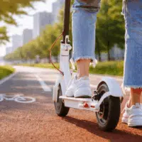 Personne circulant en trottinette électrique sur une piste, illustration de l’usage réglementé et des obligations légales liées à l’homologation.