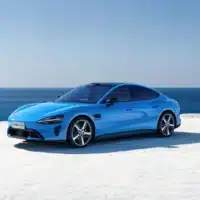 Berline électrique Xiaomi SU7 bleue stationnée en bord de mer, illustrant le positionnement premium et le design sportif du modèle