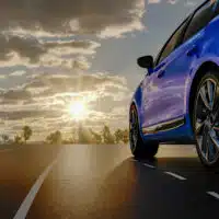 Voiture bleue circulant sur une route dégagée, illustrant l’évolution des préférences de couleur sur le marché automobile français