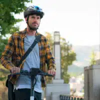 Utilisateur de trottinette électrique portant un casque en ville