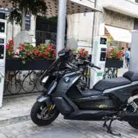 Moto électrique en recharge sur une borne en environnement urbain