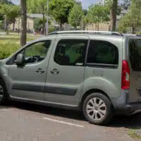Citroën Berlingo stationné en zone urbaine, vu de profil arrière, utilisé comme véhicule familial ou utilitaire