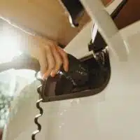 Main branchant un câble de recharge sur une borne de recharge pour voiture électrique, illustrant l’usage quotidien des infrastructures de mobilité électrique