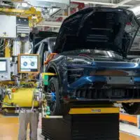 Porsche Cayenne Electric en cours d’assemblage sur une chaîne de production européenne, illustrant la fabrication industrielle et l’intégration des technologies électriques.