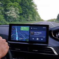 Écran Android Auto affichant Google Maps en mode écran partagé, avec l’icône du véhicule absente pendant la navigation GPS, vu depuis l’habitacle d’une voiture roulant sur route. Illustration d’un bug d’affichage affectant la localisation dans Android Auto.