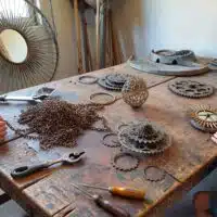 Atelier de création où adultes et enfants transforment des pièces de vélo recyclées en objets décoratifs et utilitaires.