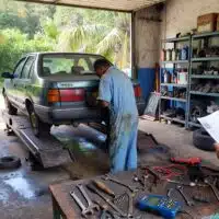 Garage automobile en Martinique avec un véhicule sur pont élévateur, illustrant le coût élevé de l’entretien et des réparations sur l’île.