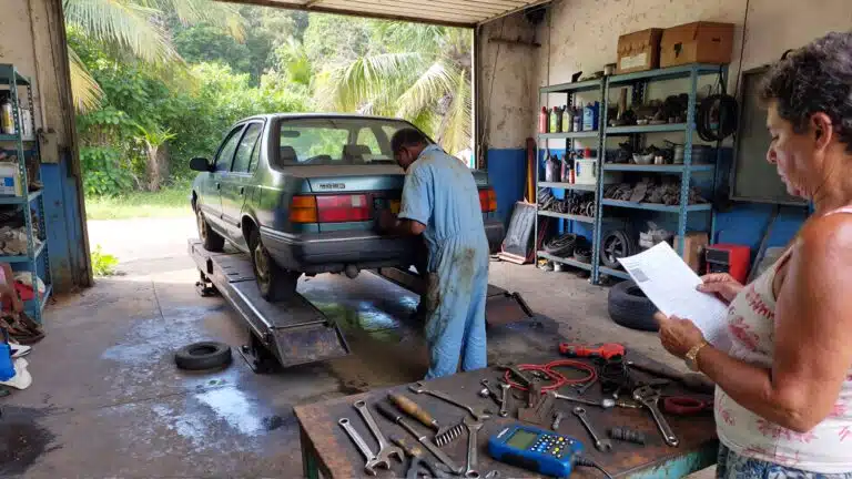 Garage automobile en Martinique avec un véhicule sur pont élévateur, illustrant le coût élevé de l’entretien et des réparations sur l’île.