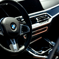 Intérieur d’une BMW avec volant et tableau de bord éclairés, illustration du modèle concerné par un rappel pour défaut potentiel du démarreur.