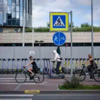 Cyclistes et utilisateurs de trottinettes électriques circulant sur une piste cyclable urbaine, illustrant les enjeux de sécurité et le débat sur le port du casque.