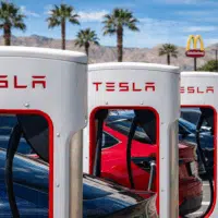 Station de recharge Tesla Supercharger avec plusieurs voitures électriques en charge