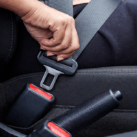 Personne attachant sa ceinture de sécurité dans une voiture moderne