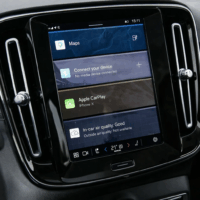 Interface Android Automotive affichée sur l’écran central d’une voiture Volvo avec navigation et Apple CarPlay.