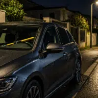 Voiture stationnée la nuit avec dispositif antivol visible. Comment protéger sa voiture contre le vol.