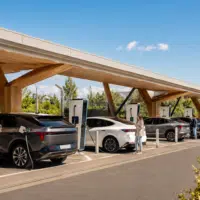 Grande station de recharge rapide pour voitures électriques en France avec plusieurs véhicules modernes branchés sur des bornes dans un environnement urbain contemporain.