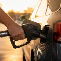 Automobiliste faisant le plein de carburant avant un départ en vacances