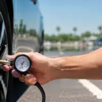 Vérification de la pression d'un pneu de voiture par forte chaleur en été