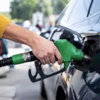 Automobiliste faisant le plein à une station-service, illustrant la prime carburant de 100 euros